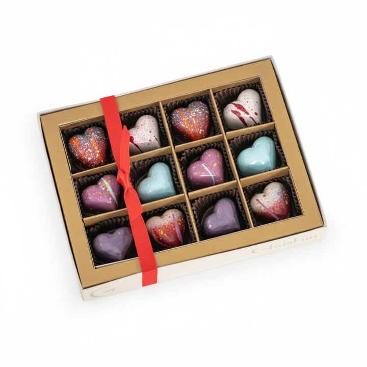The Ghyslain 12-piece Valentine Window Box featuring a metallic gold border and colorful chocolates.