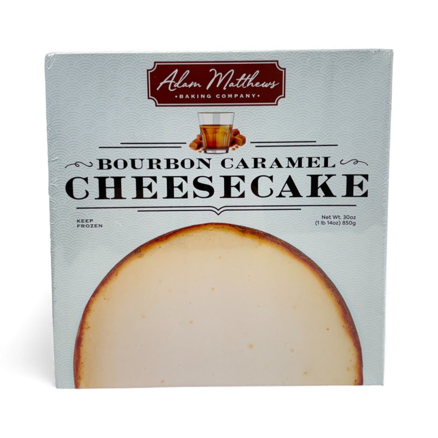 Packaged bourbon caramel cheesecake with Adam Matthews Baking Company logo on a white background