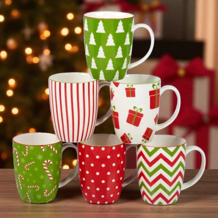 Set of Christmas-themed mugs with patterns on a wooden surface.
