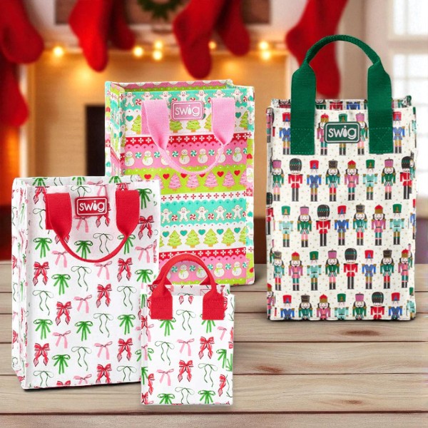 A grouping of tall reusable gift bags in the  Ribbons & Bows, Classic Nutcracker, and Cookie Jar prints from Swig.