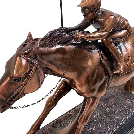 detail of copper plated statue of a horse and rider on a white background