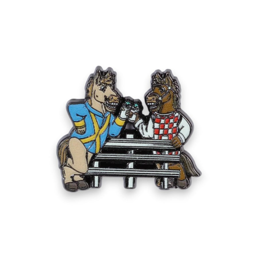 A playful enamel pin showing two cartoon horses drinking at the fence.