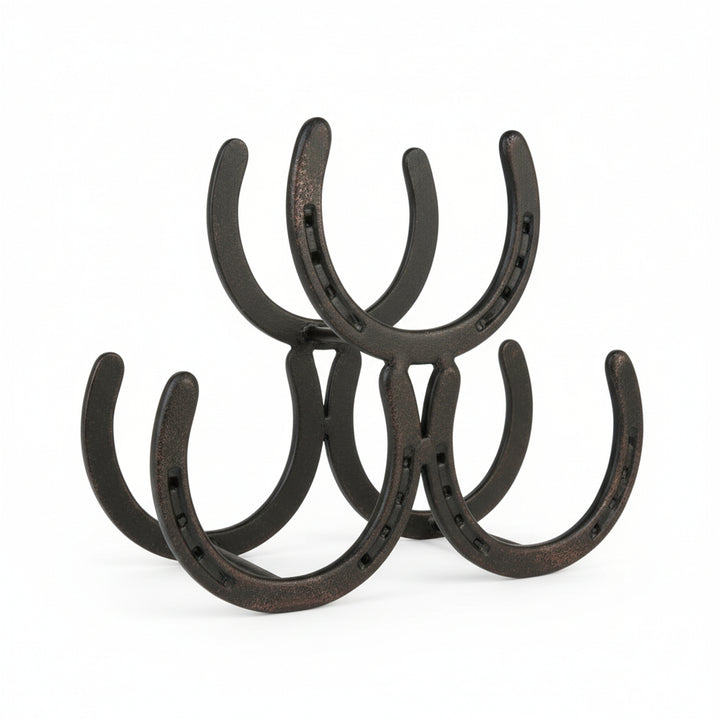 A rustic metal wine rack made of interconnected horseshoes holding three wine bottles on a kitchen counter.