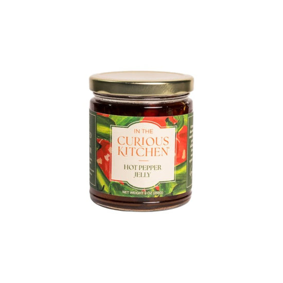 Jar of hot pepper jelly from 'In the Curious Kitchen' on a white background