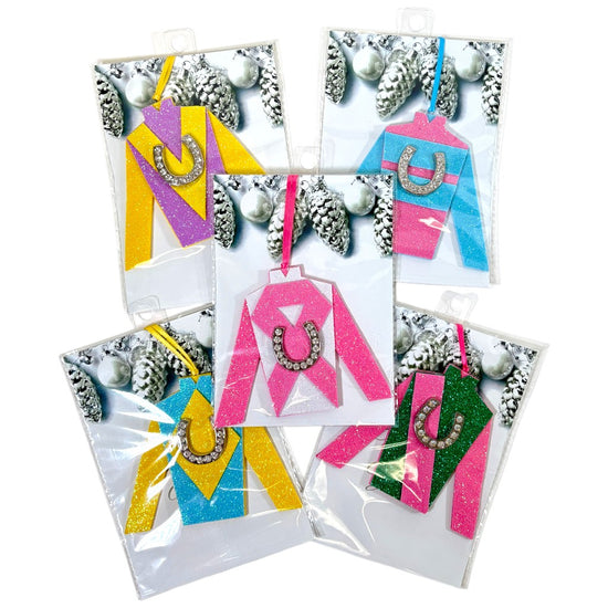 A group shot of all five handcrafted jockey silk ornaments hanging on a Christmas tree.