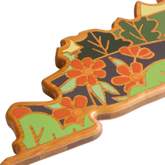 Decorative item shaped like a leaf with floral patterns on a white background
