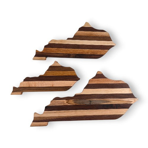 Three wooden cutting boards shaped like the state of Kentucky on a white background
