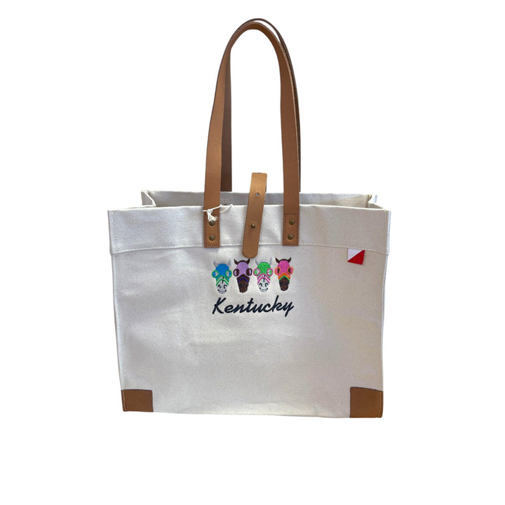 Front view of the off-white heavyweight canvas Carmel Tote featuring tan leather handles and custom embroidered horse heads above a navy Kentucky script.