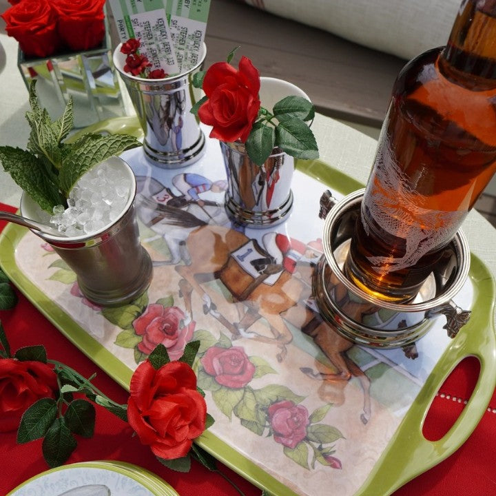 A lifestyle shot of the rectangular serving tray filled with appetizers and drinks, being carried by a host at an outdoor garden party.