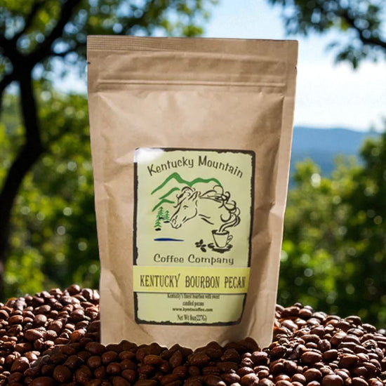 Kentucky Mountain Coffee Company bag of Kentucky Bourbon Pecan coffee on a bed of coffee beans with a scenic background.