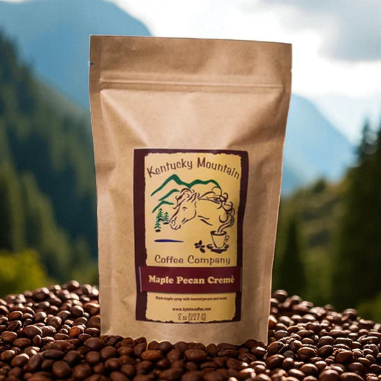 Kentucky Mountain Coffee Company Maple Pecan Creme coffee package on coffee beans with a mountainous background