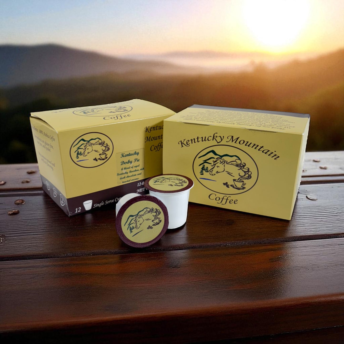 Kentucky Mountain Coffee boxes and pods on a wooden surface with a scenic background