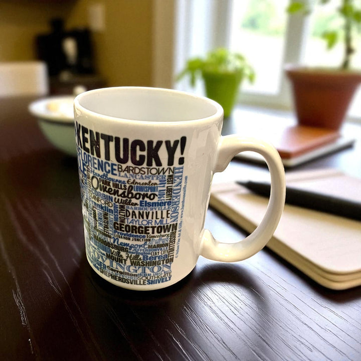 White mug with blue and black text on a wooden table