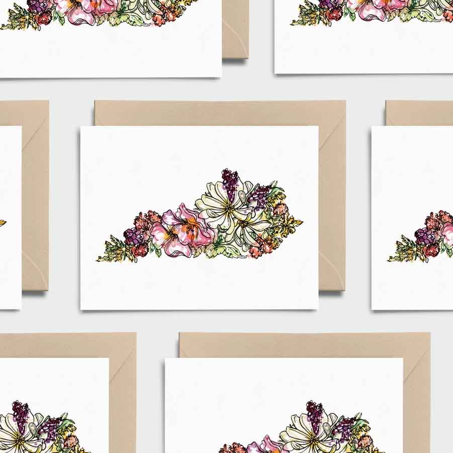 Floral designs on greeting cards with brown envelopes against a white background