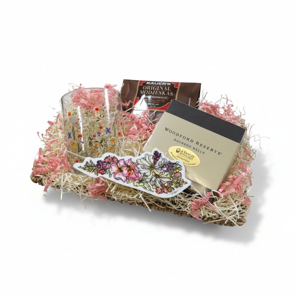 The Kentucky Wildflowers for Her Gift Basket featuring a floral rocks glass, sticker, and Woodford Reserve chocolates.