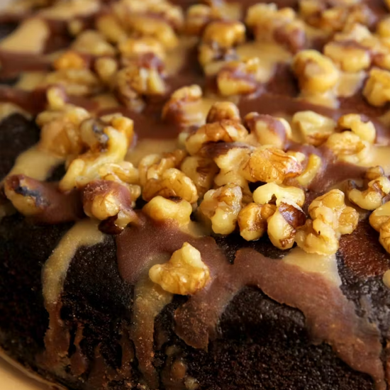 Close-up of a chocolate cake with caramel and walnuts