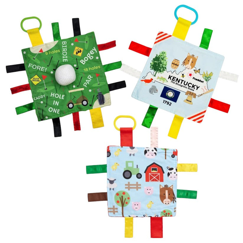 A group of three Learning Lovey Crinkle Tag Squares showing the Kentucky, Golf, and Farm designs.