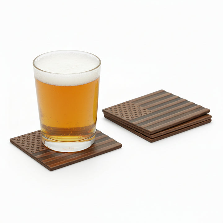 Glass of beer on a brown leather coaster, highlighting the American flag graphic with a set of coasters in the background