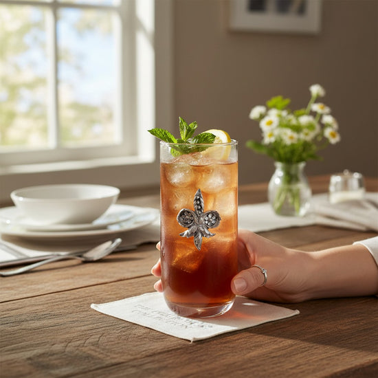 The Fleur De Lis Iced Tea Glass filled with a refreshing beverage and styled on a beautifully set table.