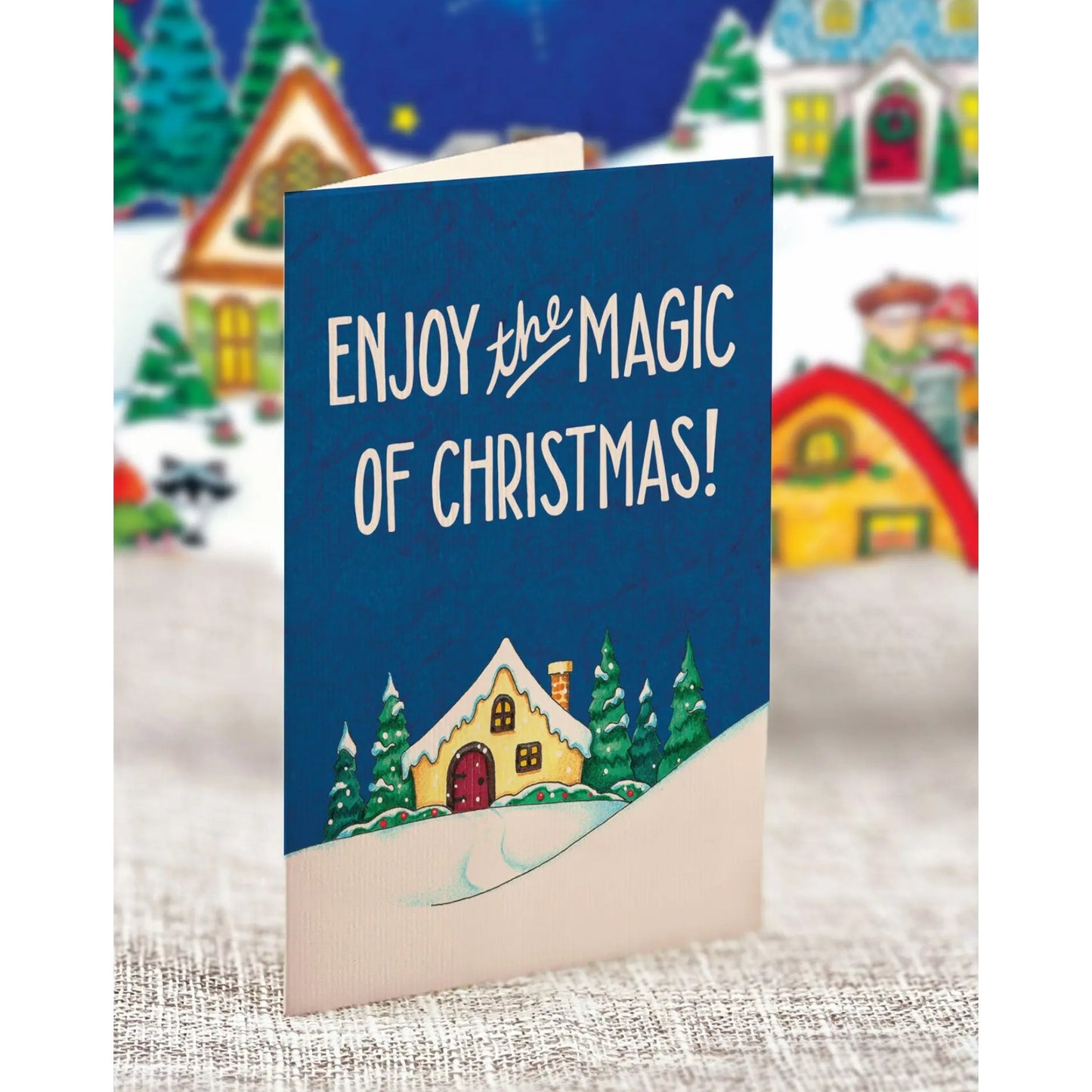Christmas card with 'Enjoy the Magic of Christmas!' text and festive village background