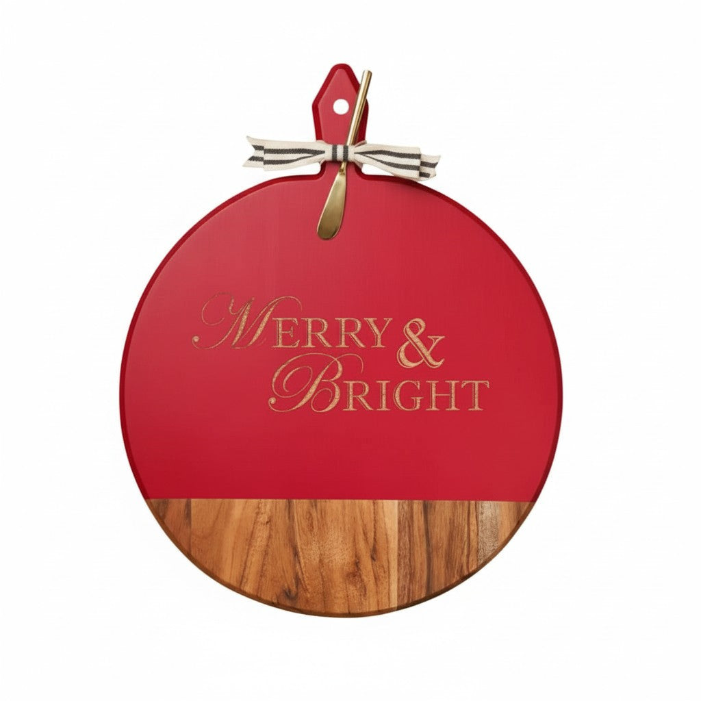 The round "Merry & Bright" acacia wood serving board with gold spreader on a white background.