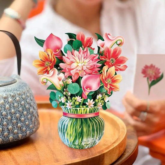 The Mini Dear Dahlia pop-up card standing on a tabletop, showing its compact size and beautiful pink paper flowers.