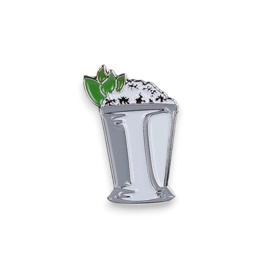 A classic silver mint julep cup enamel pin, filled with ice and garnished with fresh mint leaves.