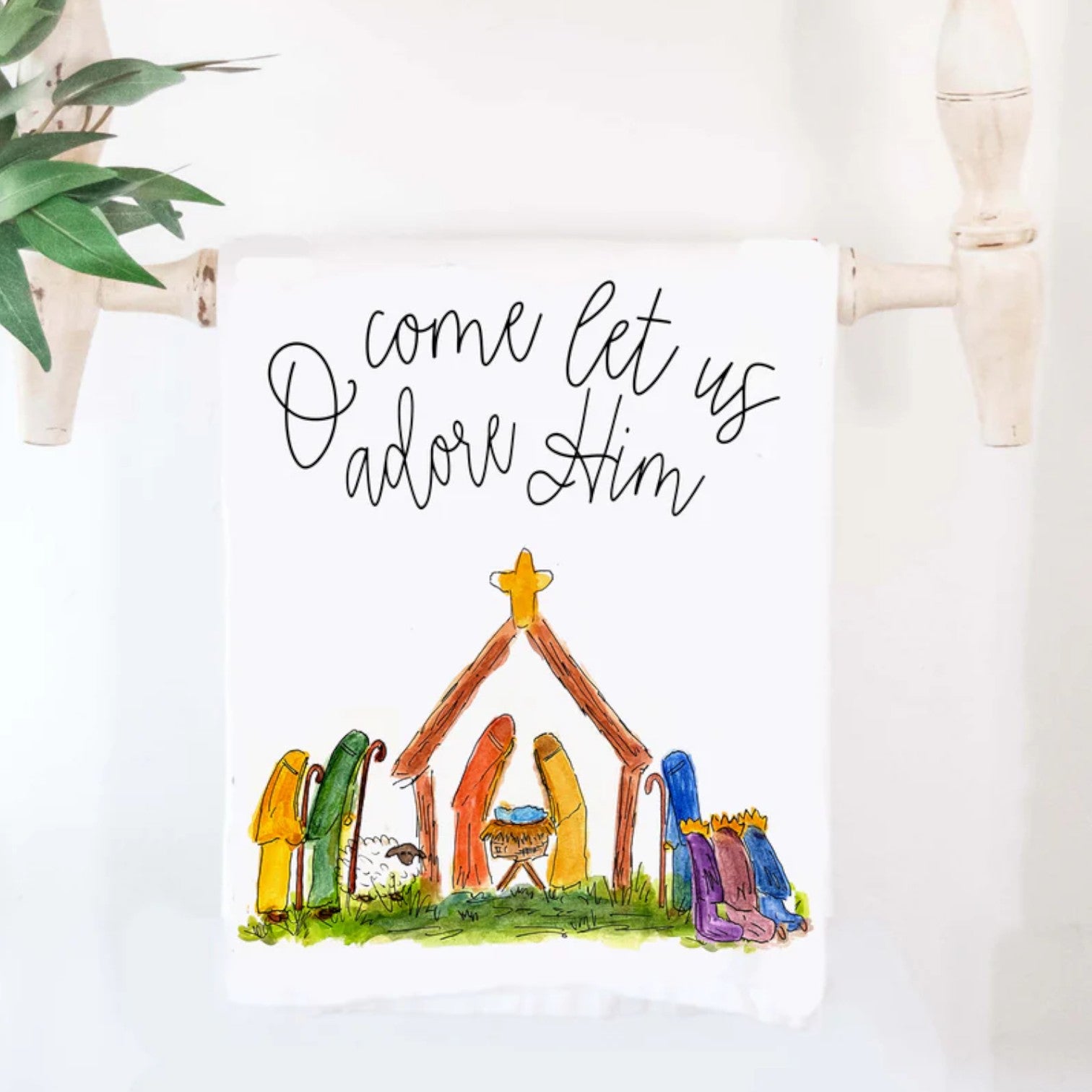 The "Nativity Adore Him" cotton tea towel, showing its serene and beautiful religious artwork.