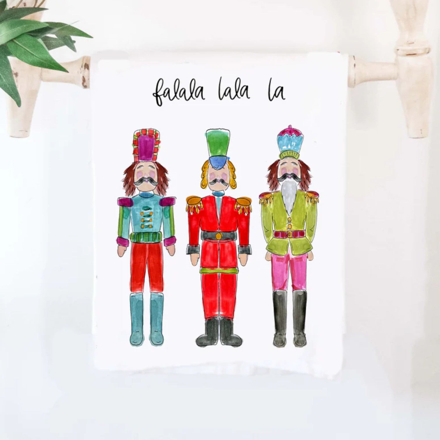 The colorful "Nutcracker Artwork" cotton tea towel, showcasing its classic holiday ballet design and 'falala la la la' text.