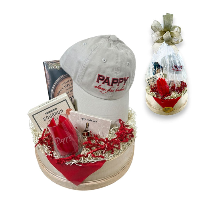 The Pappy Bourbon Experience Gift Basket featuring a Pappy hat, tasting glass, book, and bourbon balls.