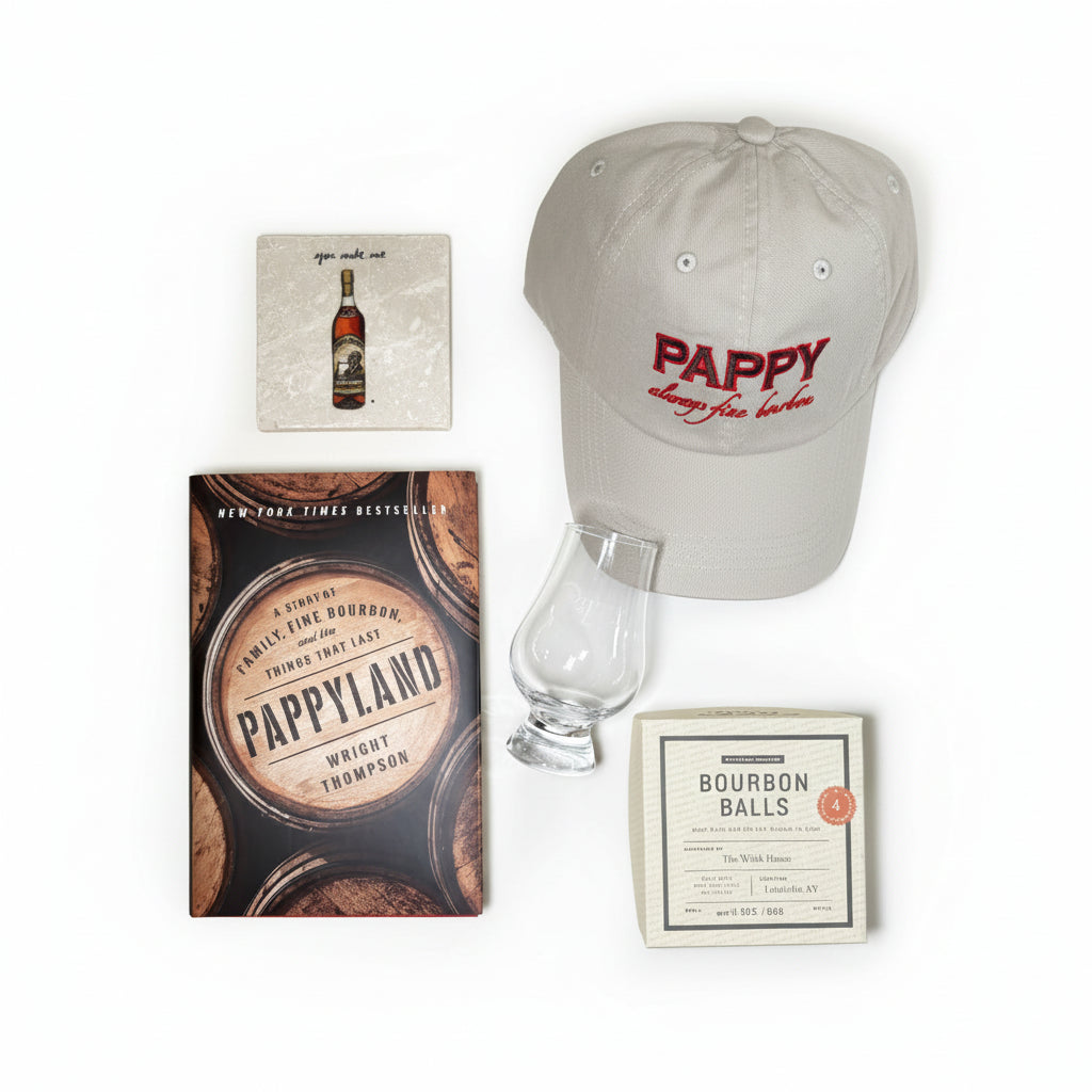 Top-down view of the gift basket contents: Pappy hat, coaster, tasting glass, Pappyland book, and chocolates.