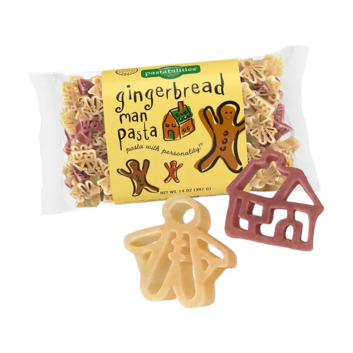 Packaged gingerbread man pasta with a house-shaped piece on a white background