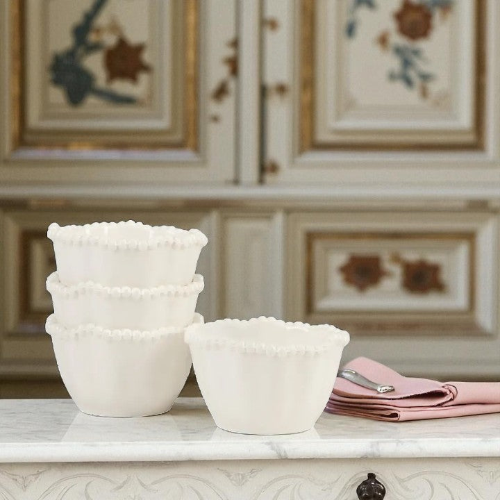 Set of white ceramic bowls on a marble surface with decorative background
