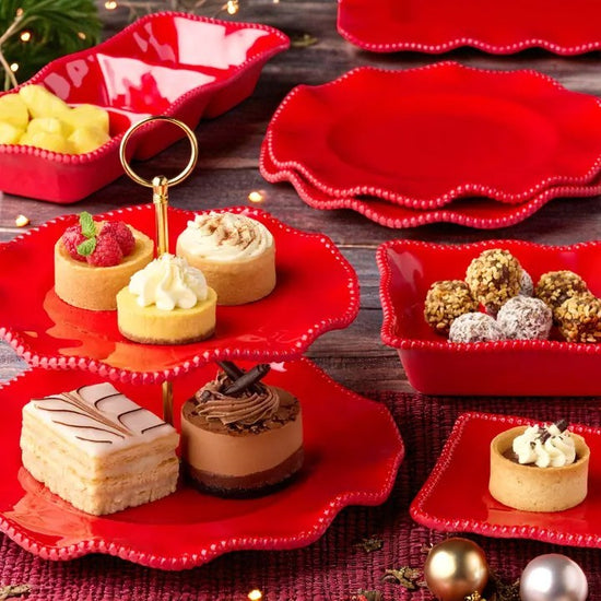 Red dessert stand with various small desserts on a wooden surface
