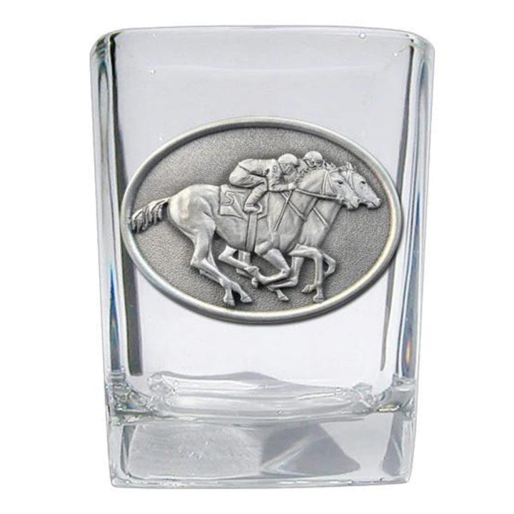 Clear glass shot glass with a silver horse and jockey emblem on a white background