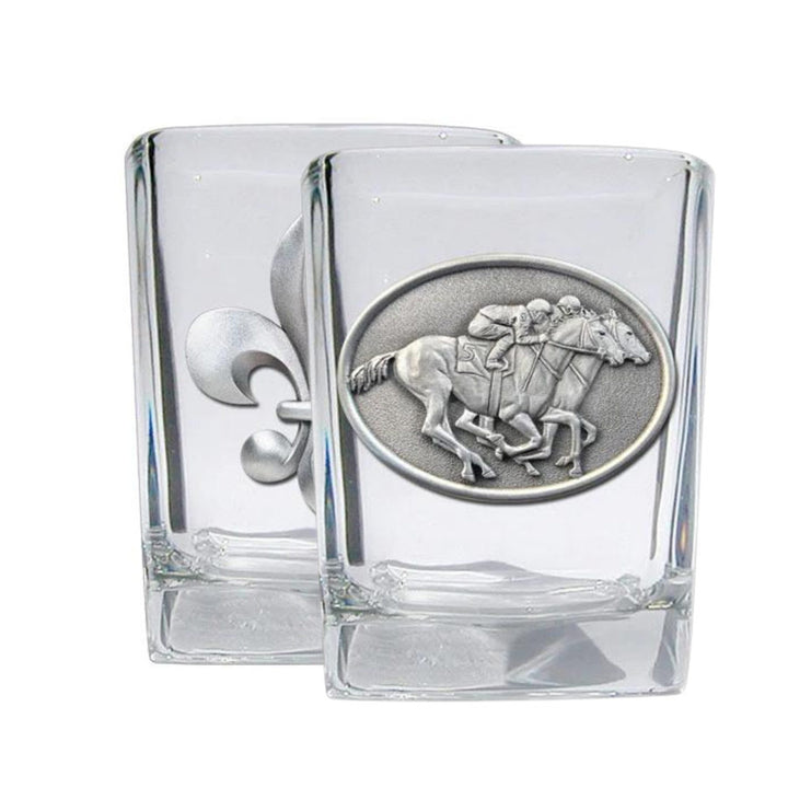 Clear glass shot glasses with metal horse and jockey emblem on a white background