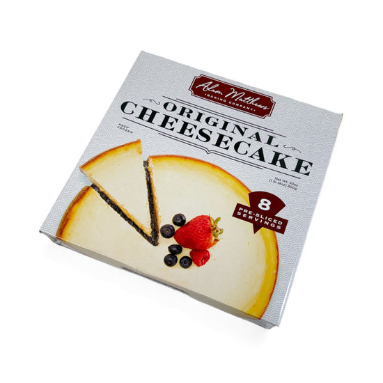 Box of Adam Miller's Original Cheesecake with a slice of cheesecake and berries on a white background