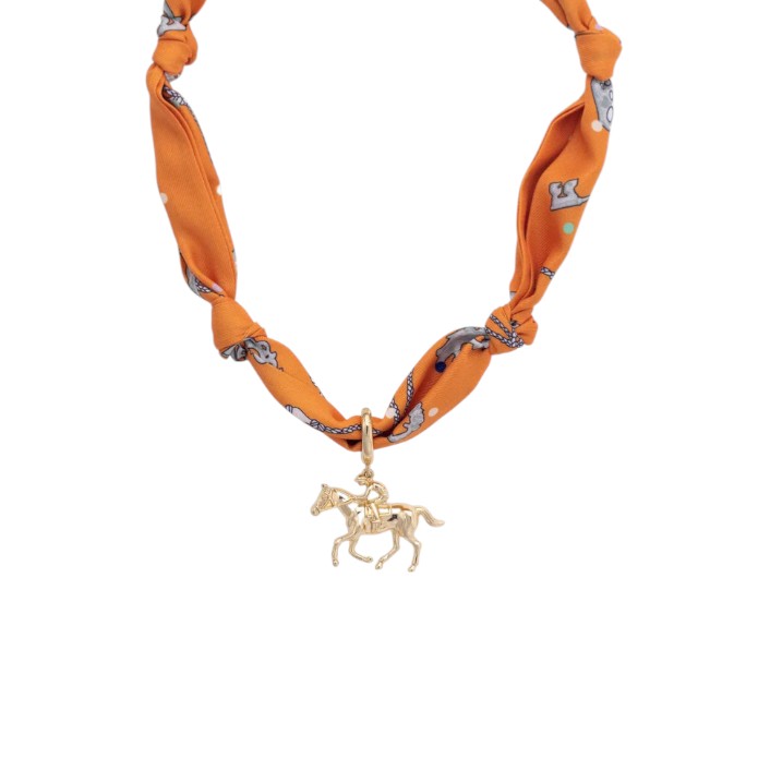 Close-up detail of the orange silk pattern and gold spring attachment on the scarf necklace.