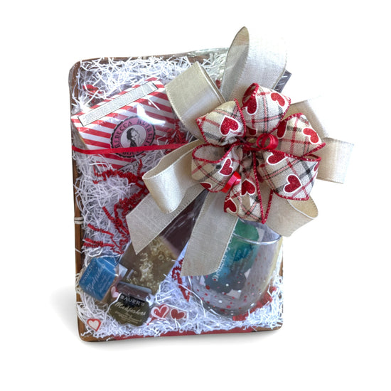 The Sip & Savor Gift Basket beautifully arranged, featuring a wine chiller, a stemless wine glass, and Kentucky bourbon sweets.