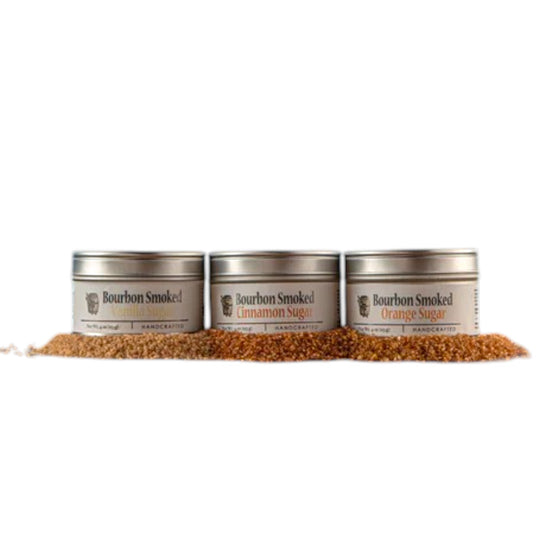 Three separate tins showcasing the Bourbon Smoked Cinnamon, Vanilla, and Orange Sugar labels.