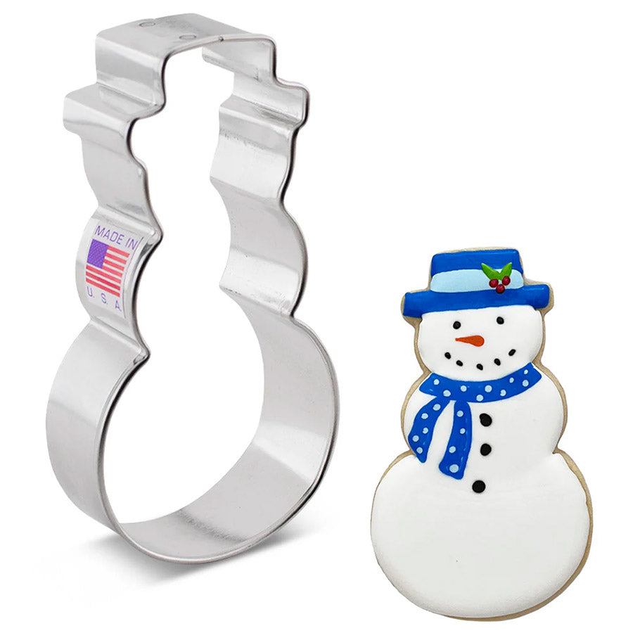 Metal snowman cookie cutter next to a decorated snowman cookie on a white background