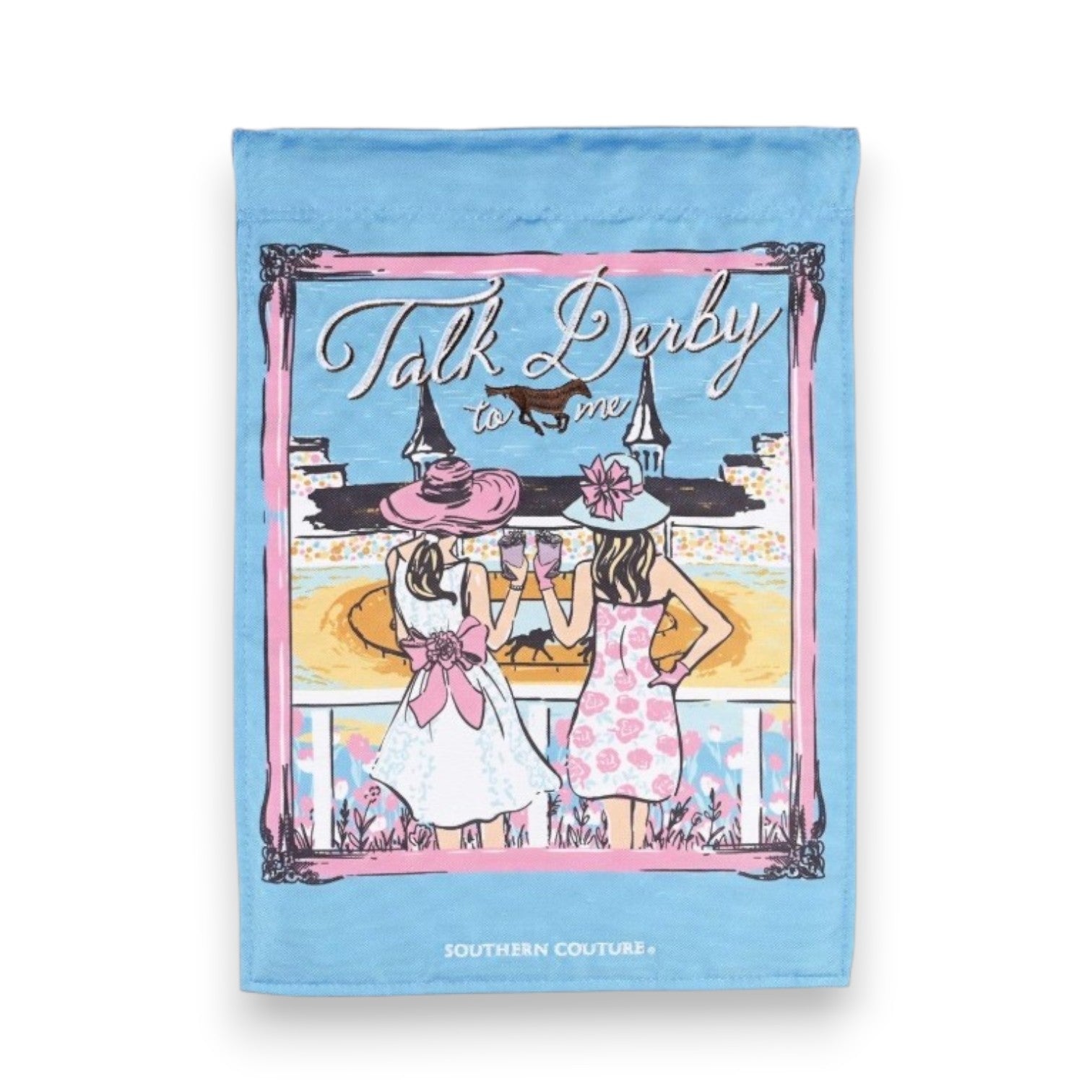 A light blue Southern Couture garden flag illustrating two fashionably dressed women in large hats toasting drinks at Churchill Downs, featuring a pink border and the white text "Talk Derby to me".