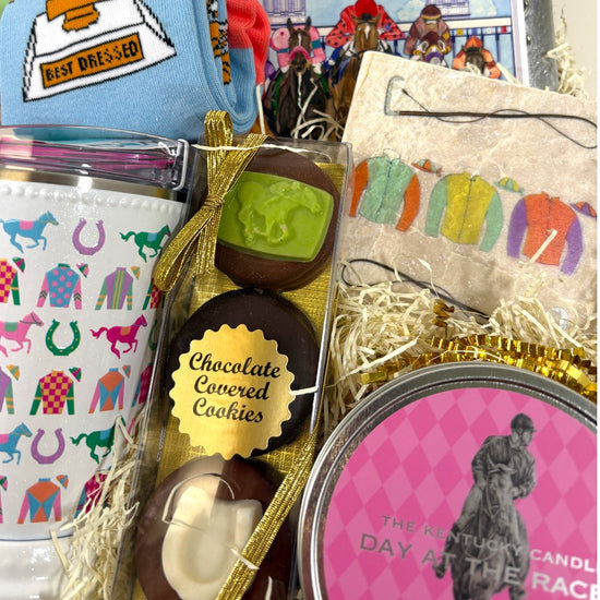 Gift basket with chocolate-covered cookies, candles, and decorative items related to horse racing.