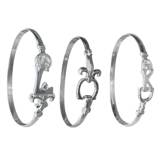 Three silver bangles with intricate designs on a white background