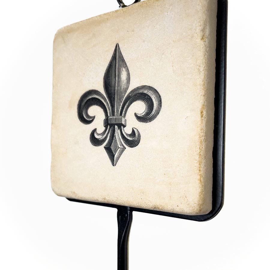 Decorative wall light with a fleur-de-lis design on an aged paper background