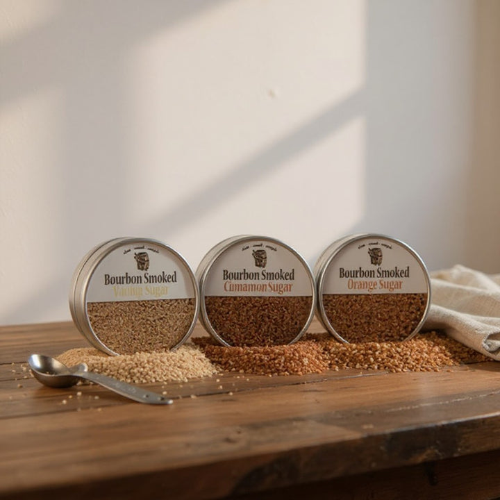 A lifestyle shot with the three sugar tins next to a cocktail and a baked good.