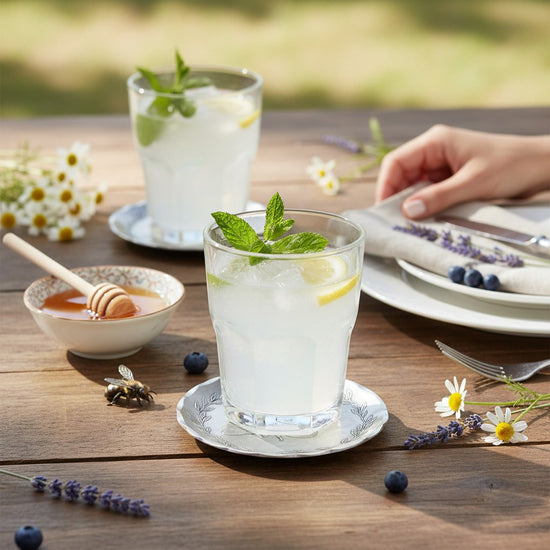 A lifestyle photo of the Honey Bee Coaster used as part of a bright, summery table setting.