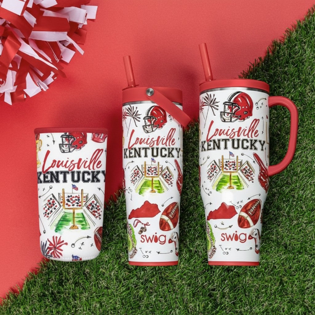Three Louisville Kentucky football themed tumblers on a red and green background, featuring red lids, handles, and straw lids with white bodies decorated with red and green football graphics and team text.