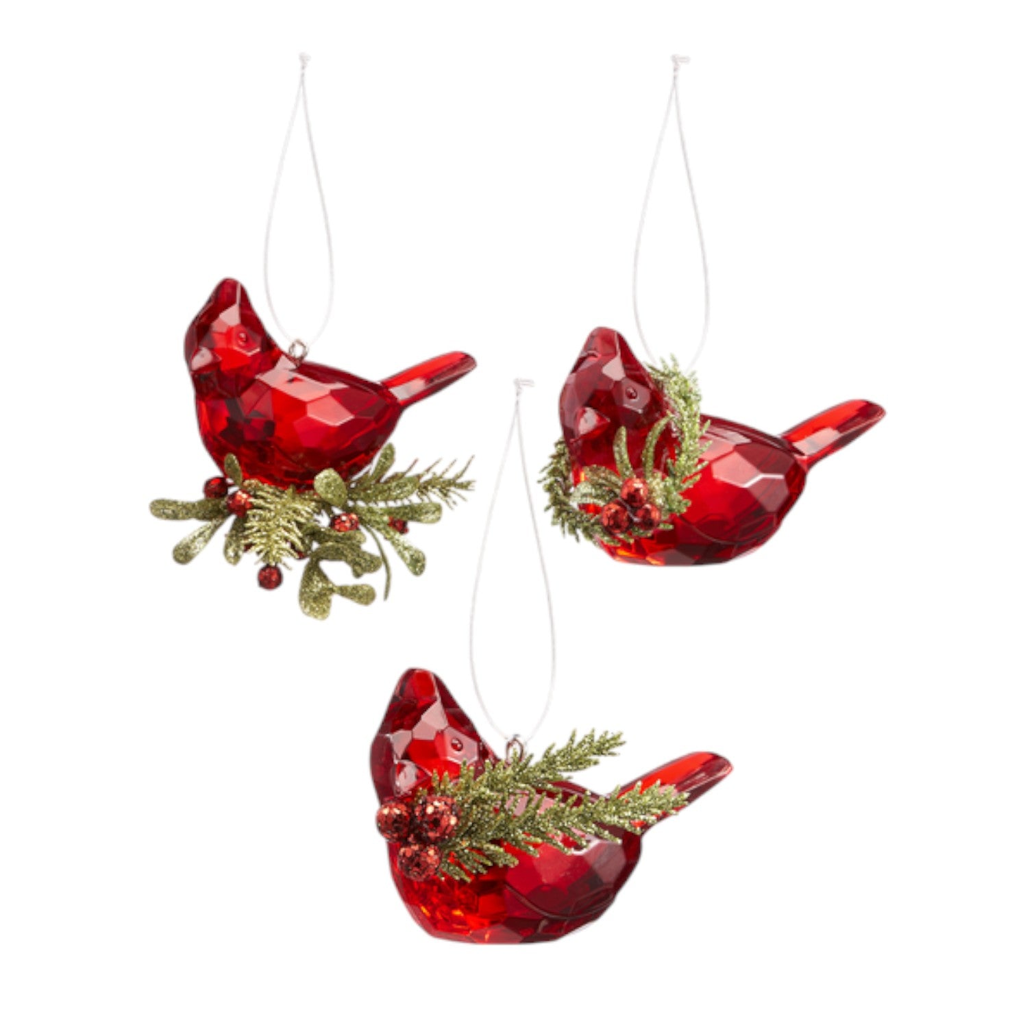 Three red glass cardinal bird ornaments with greenery on a white background
