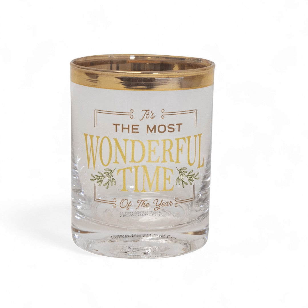A close-up view of the luxurious gold rim and shimmering lettering on a holiday glass.